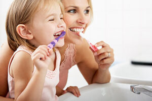 Mother and child brushing their teeth together